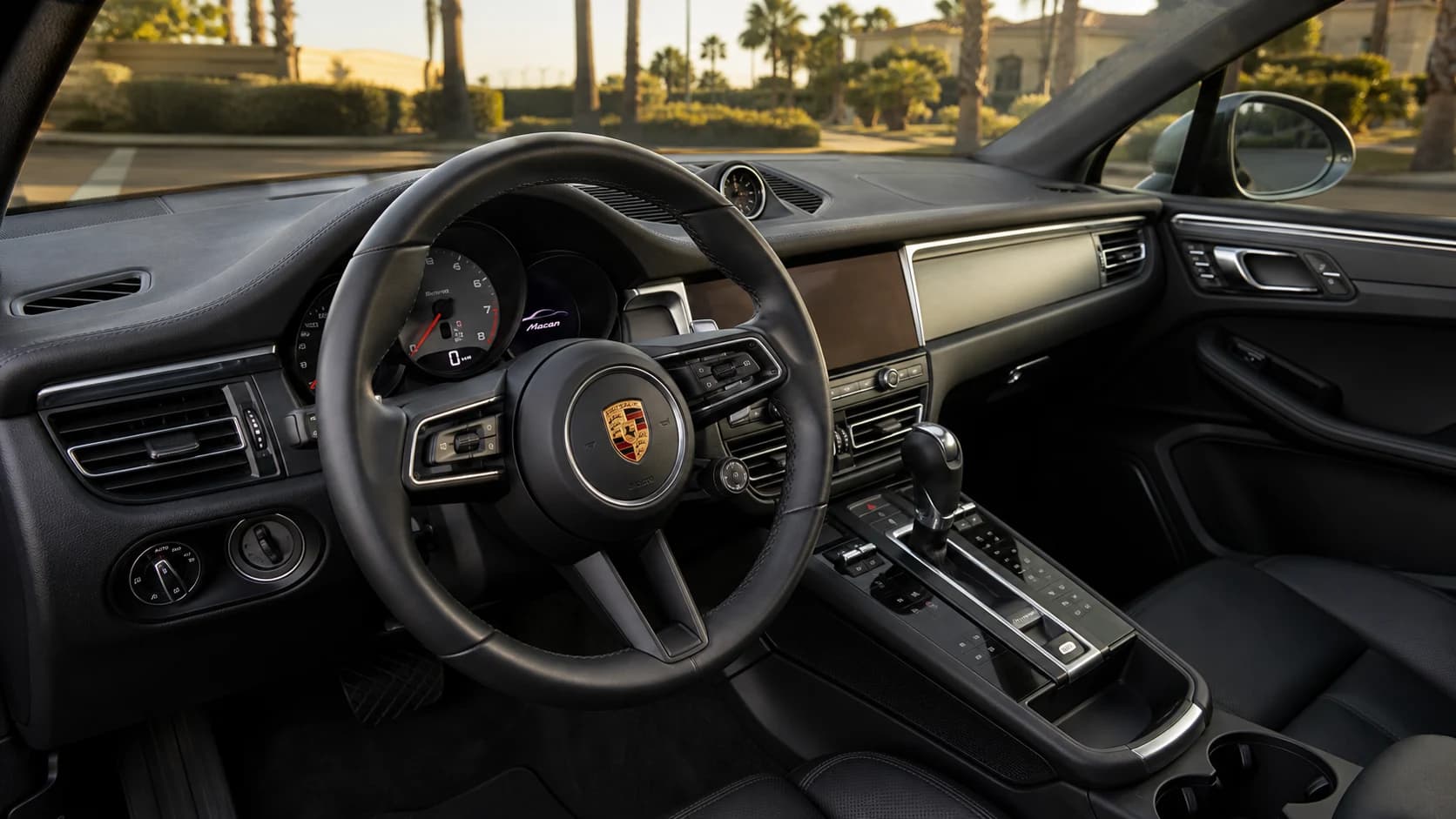Porsche Macan cockpit with the steering wheel, controls, and dashboard visible